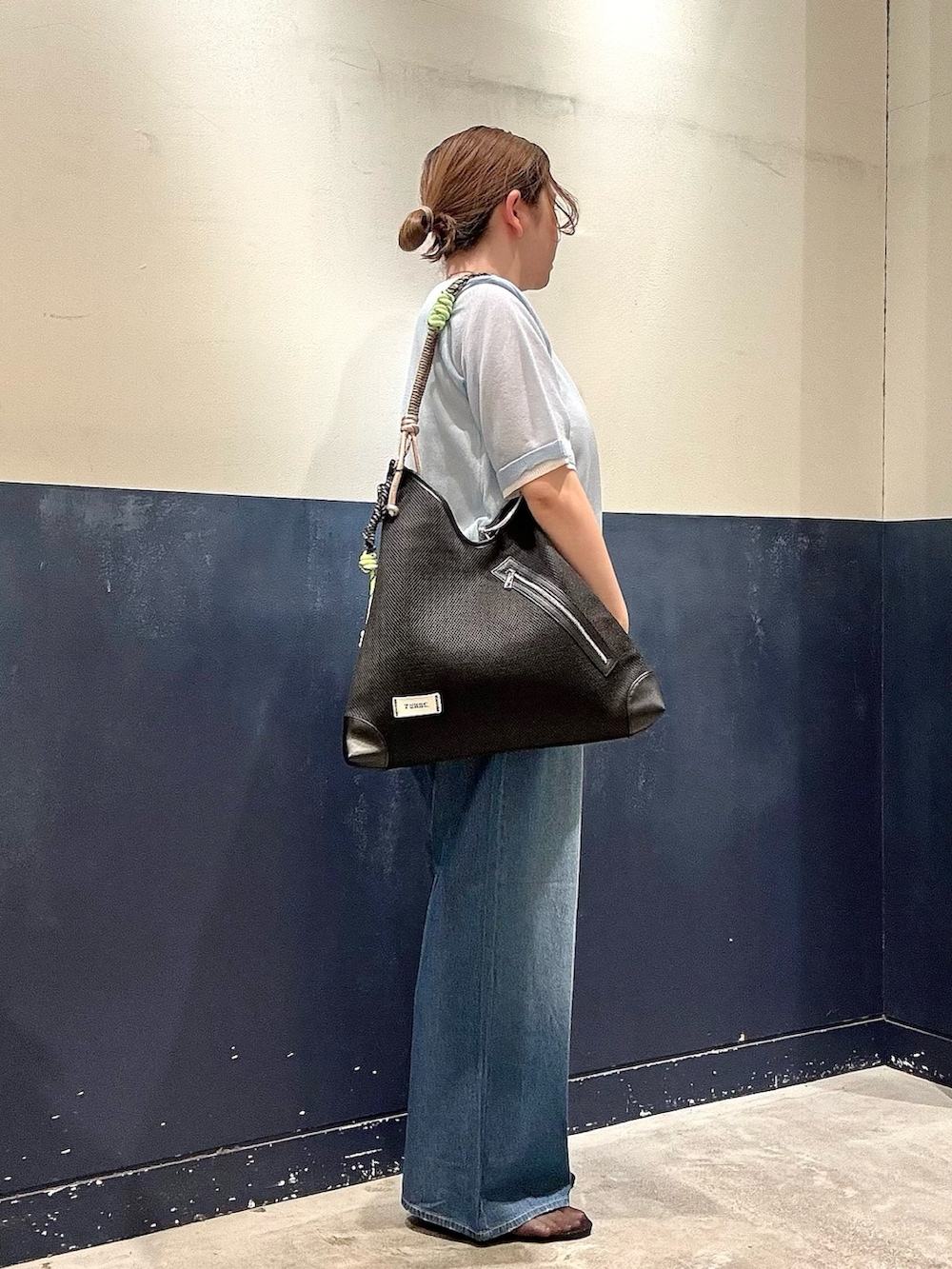 ブラック系のパンプス、ブルー系のデニムパンツ、ブラック系のショルダーバッグを着用したレディースの春コーディネートの2枚目の写真