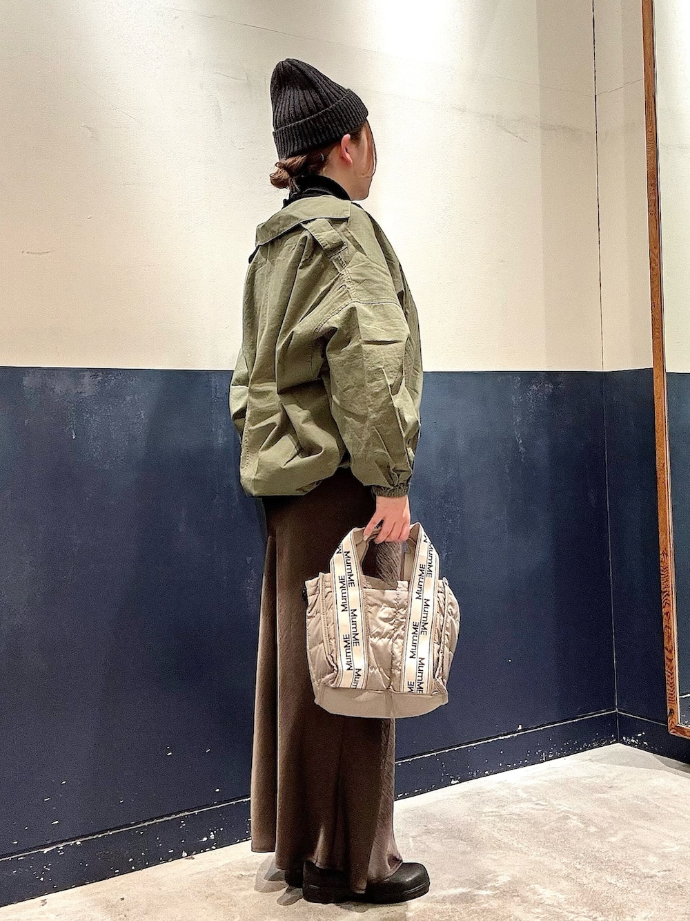 ブラック系のニット/セーター、グリーン系のブルゾン、グレー系のショルダーバッグを着用したレディースの冬コーディネートの2枚目の写真