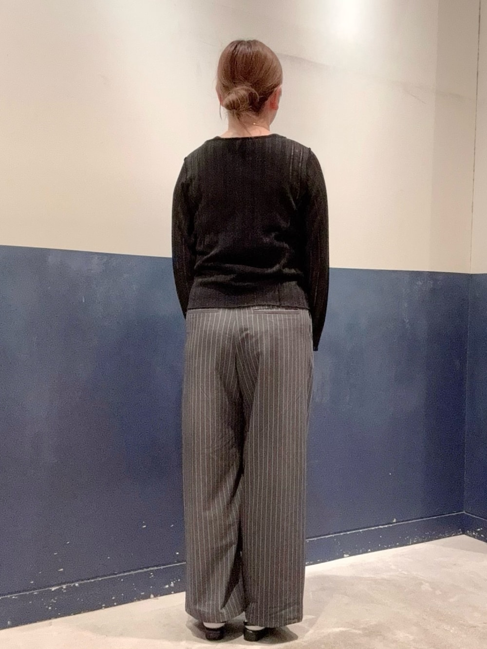 ブラック系のパンプス、グレー系のスラックス、ブラック系のタンクトップを着用したレディースの秋コーディネートの3枚目の写真