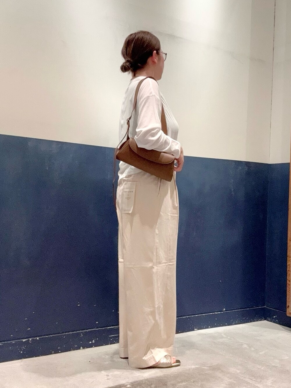 ホワイト系のデニムパンツ、ブラウン系のショルダーバッグ、ゴールド系のサンダルを着用したレディースの夏コーディネートの2枚目の写真