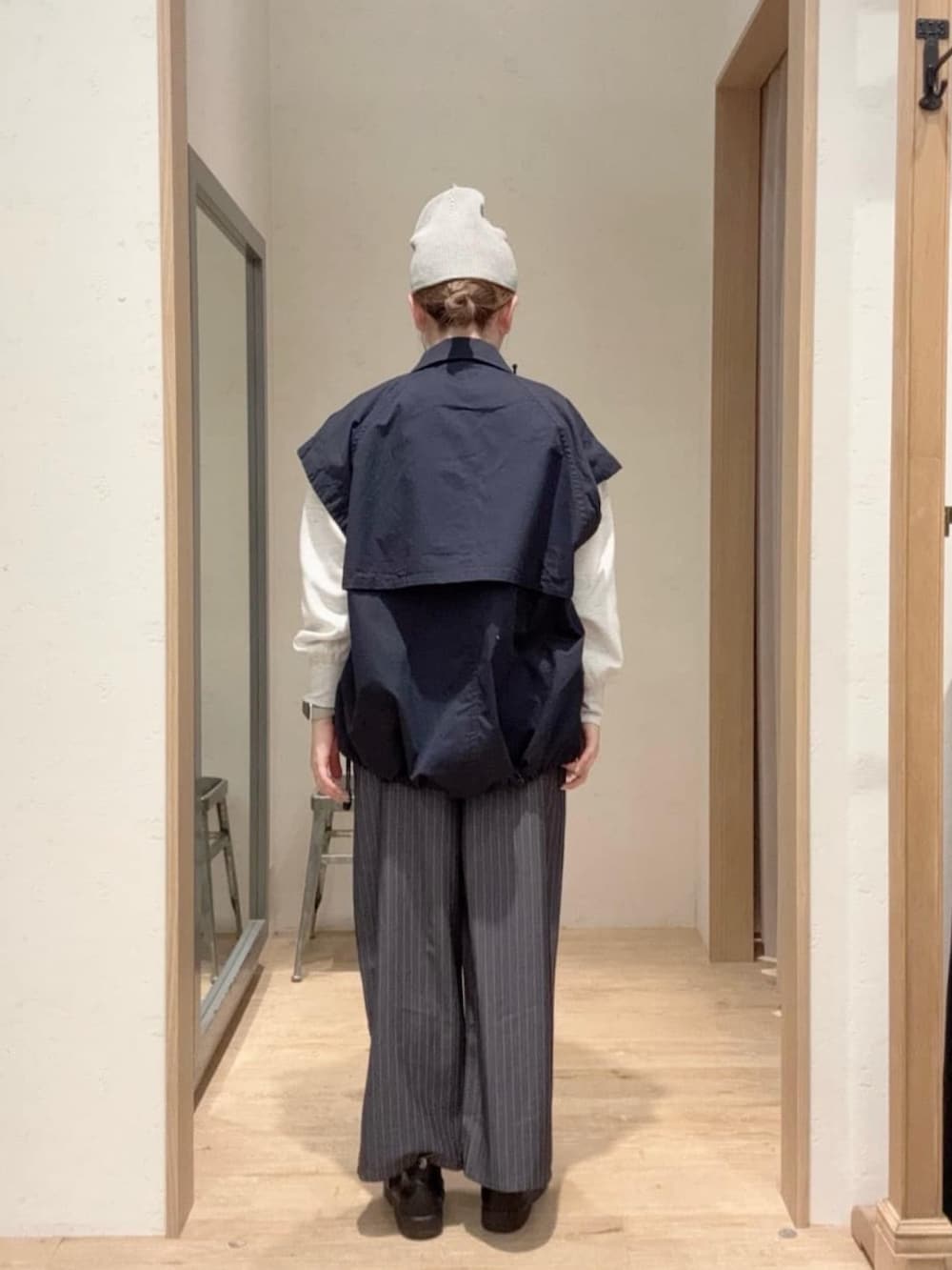 ブルー系のトレンチコート、グレー系のTシャツ/カットソー、グレー系のスラックスを着用したレディースの春コーディネートの2枚目の写真