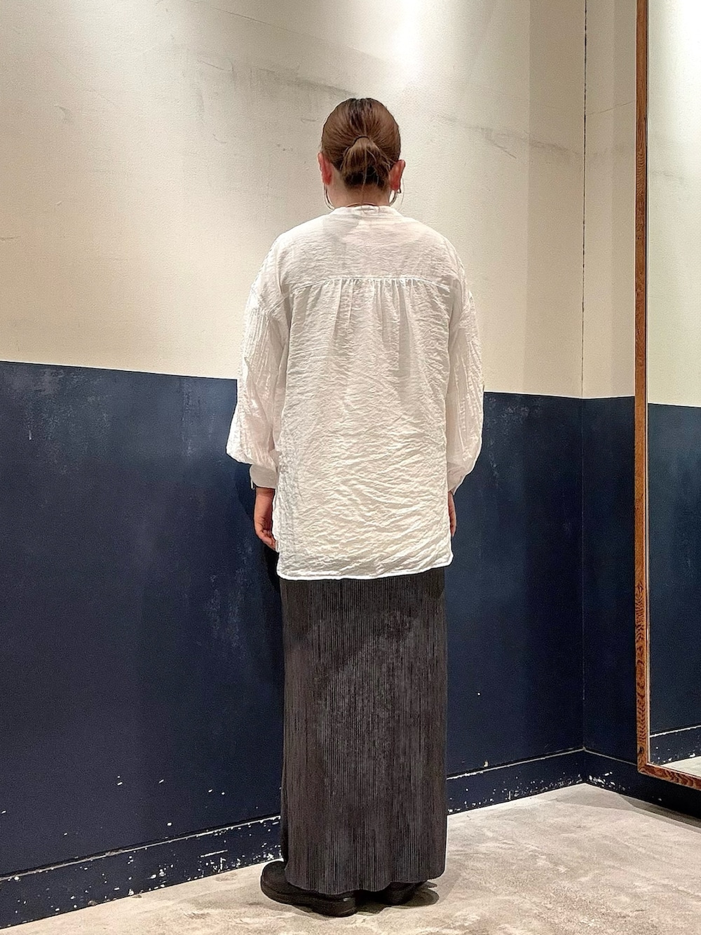 ブラック系のスカート、ホワイト系のTシャツ/カットソー、ホワイト系のシャツ/ブラウスを着用したレディースの春コーディネートの3枚目の写真