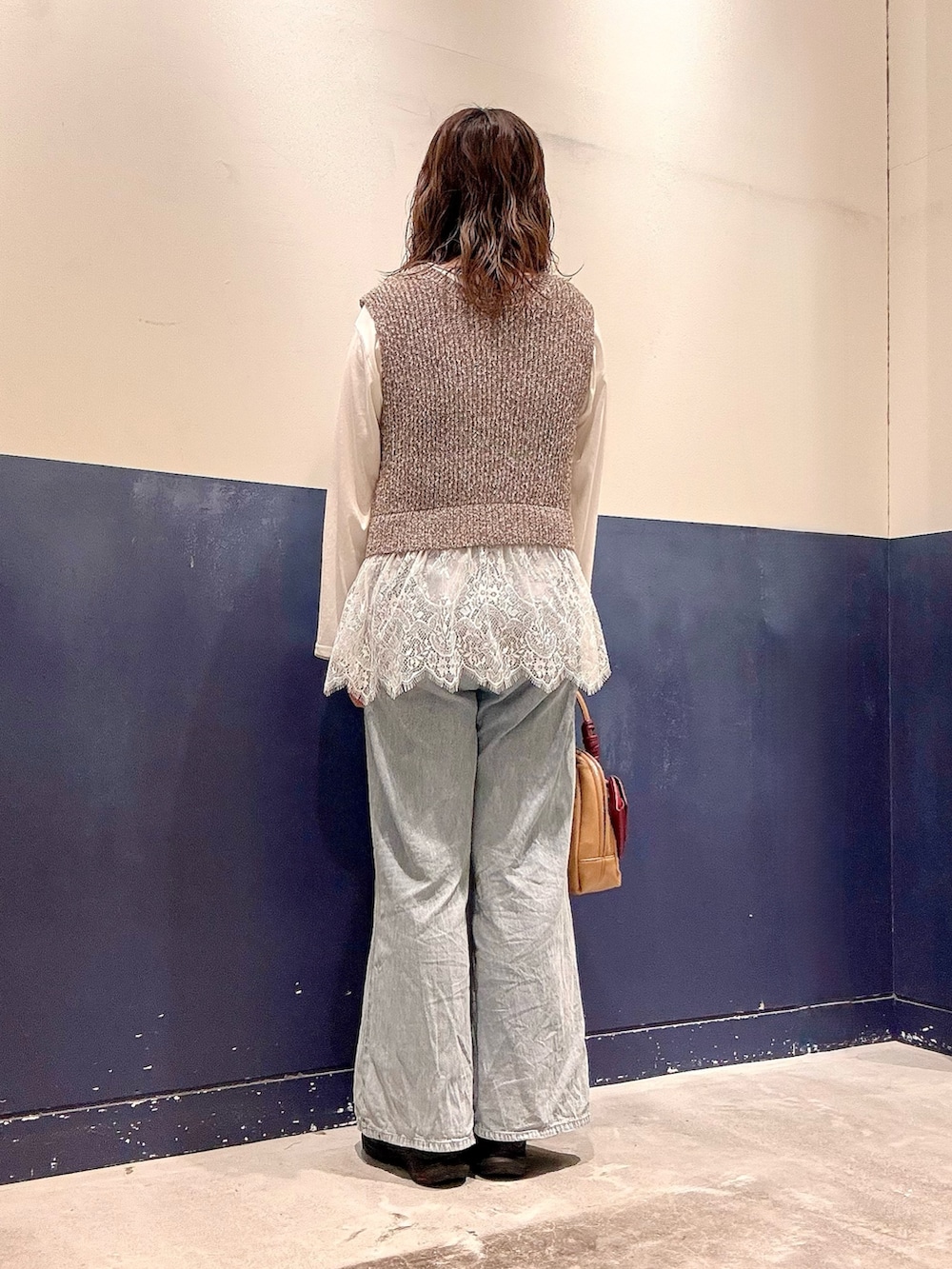 ブルー系のデニムパンツ、ブラウン系のベスト、ホワイト系のTシャツ/カットソーを着用したレディースの夏コーディネートの3枚目の写真