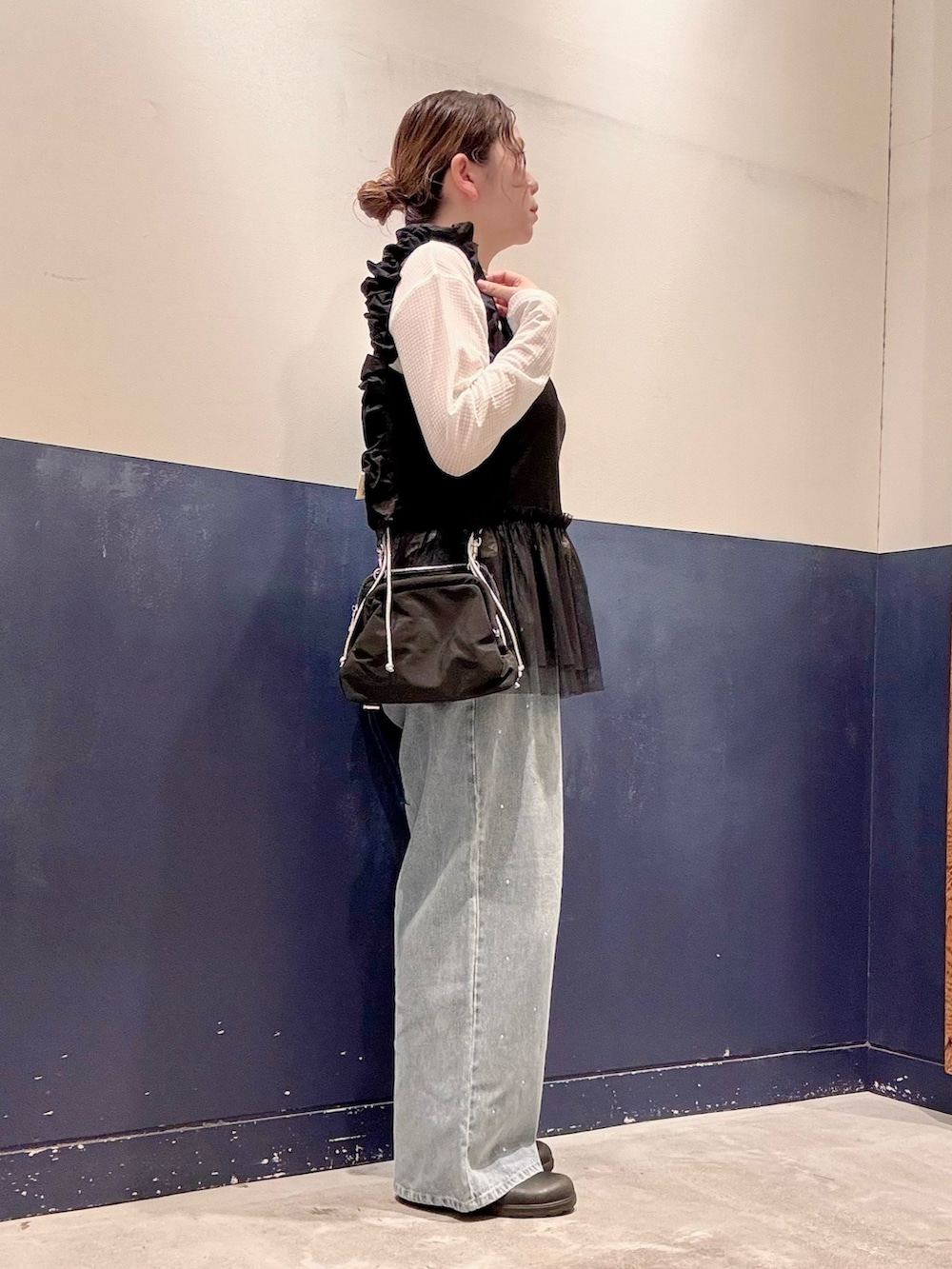 ブルー系のデニムパンツ、ブラック系のキャミソール、ブラック系のショルダーバッグを着用したレディースの秋コーディネートの2枚目の写真