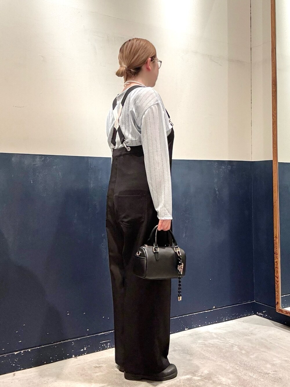 ブルー系のTシャツ/カットソー、ブラック系のサロペット/オーバーオール、ブラック系のショルダーバッグを着用したレディースの春コーディネートの2枚目の写真