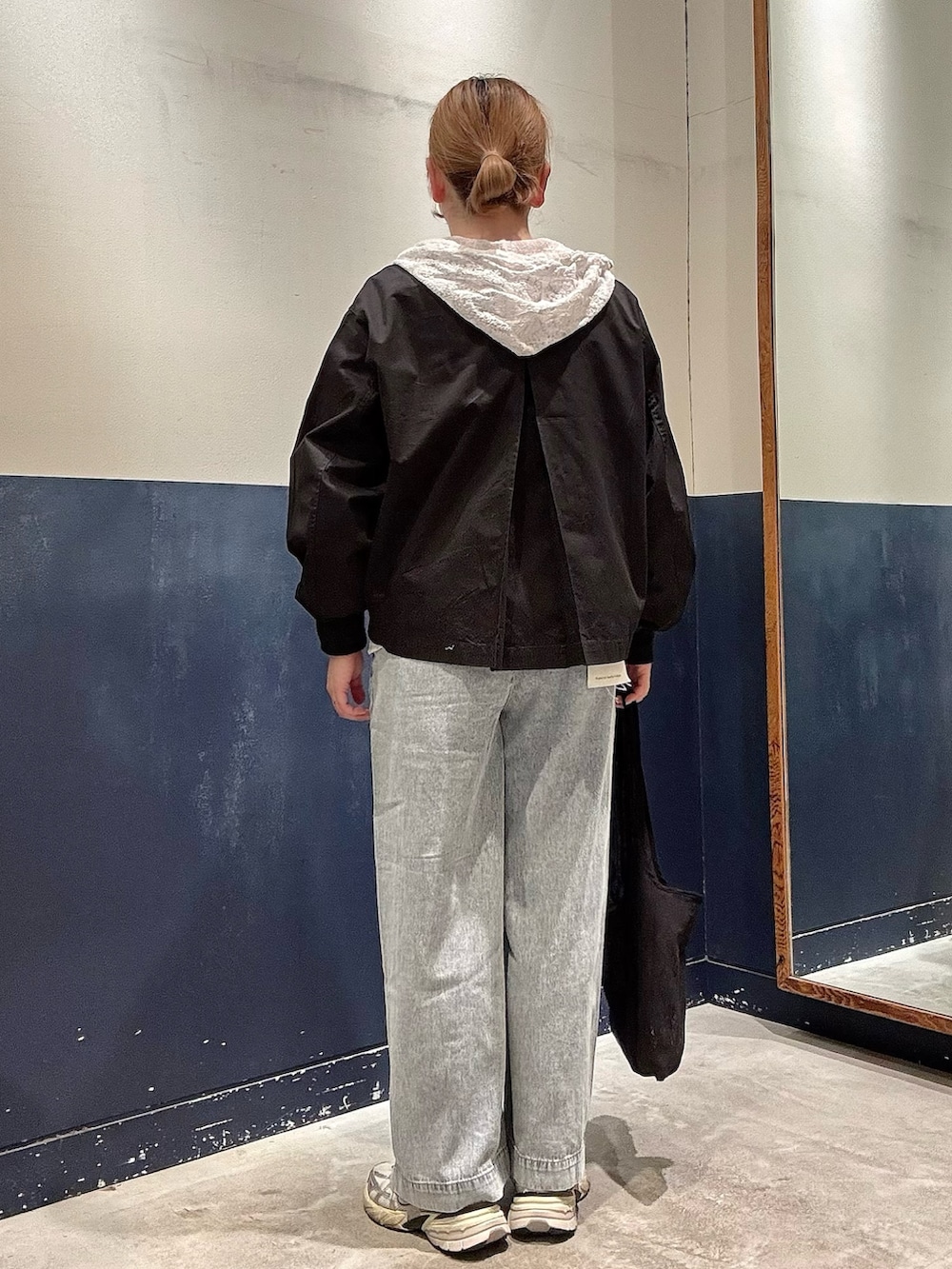 ブラック系のトートバッグ、ブルー系のデニムパンツ、ホワイト系のシャツ/ブラウスを着用したレディースの春コーディネートの3枚目の写真