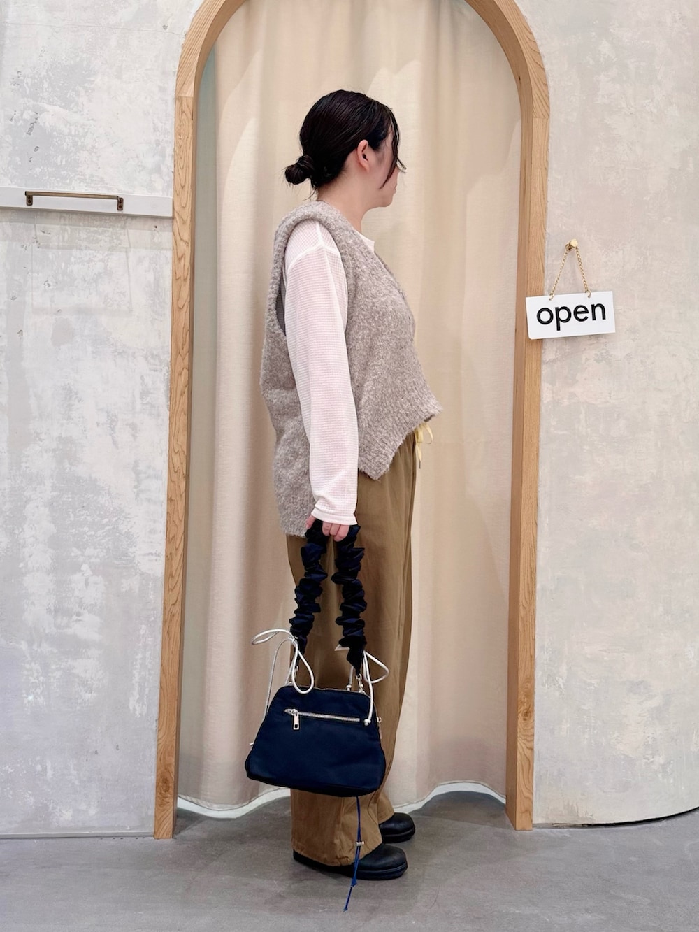 ブラック系のショルダーバッグ、ベージュ系のその他パンツ、ホワイト系のTシャツ/カットソーを着用したレディースの秋コーディネートの2枚目の写真