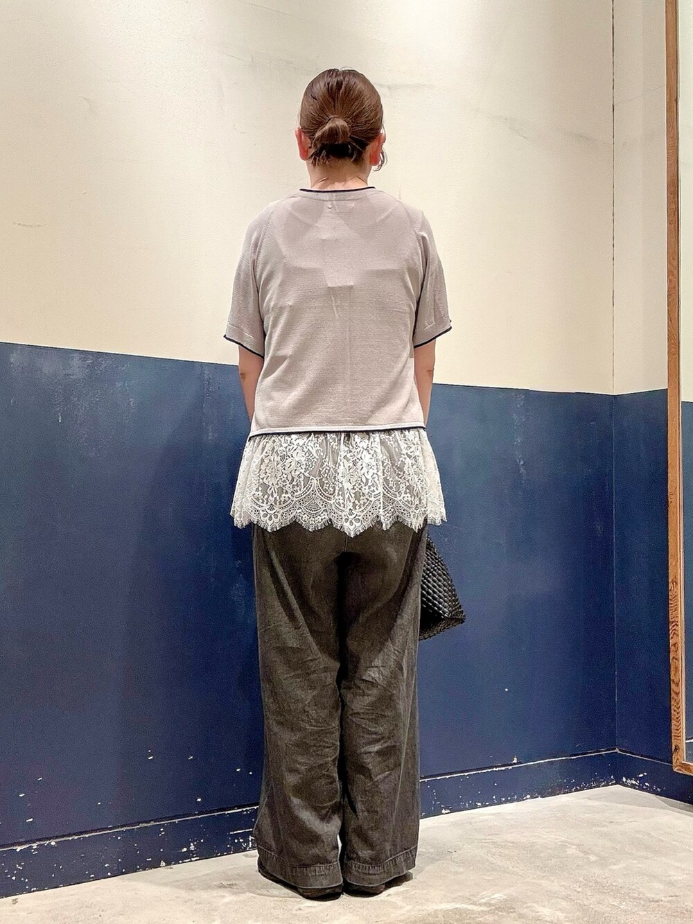 ブラック系のショルダーバッグ、ブラック系のデニムパンツ、グレー系のニット/セーターを着用したレディースの夏コーディネートの3枚目の写真