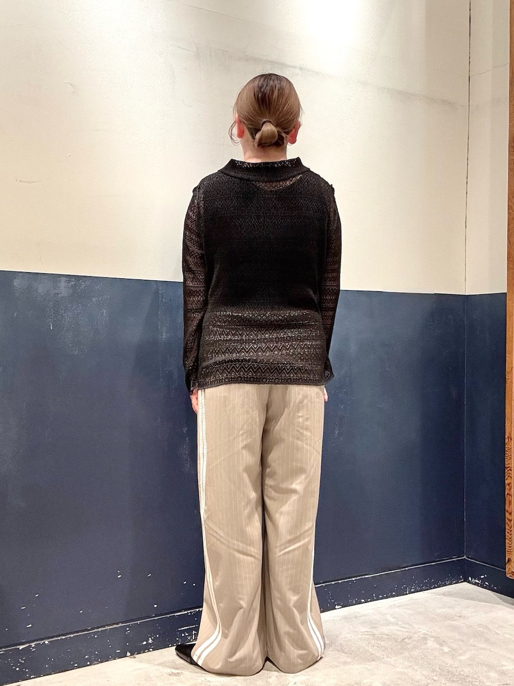 ブラック系のパンプス、ベージュ系のスラックス、ブラック系のタンクトップを着用したレディースの春コーディネートの3枚目の写真