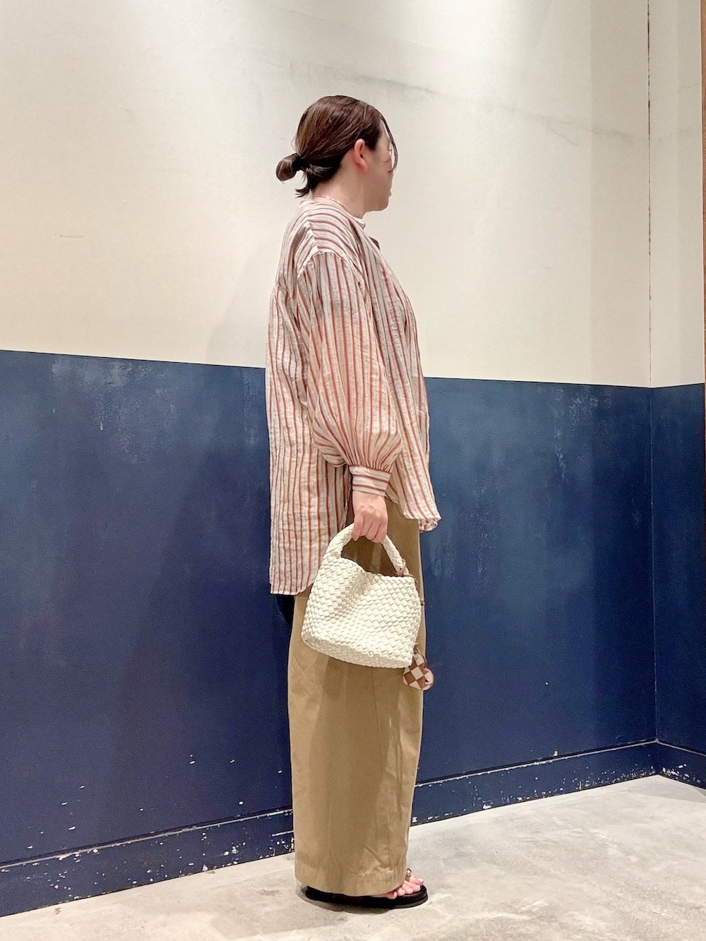 ベージュ系のデニムパンツ、ホワイト系のショルダーバッグ、イエロー系のサンダルを着用したレディースの夏コーディネートの2枚目の写真