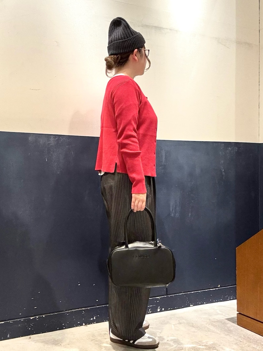 ホワイト系のTシャツ/カットソー、レッド系のカーディガン/ボレロ、グレー系のスラックスを着用したレディースの冬コーディネートの2枚目の写真