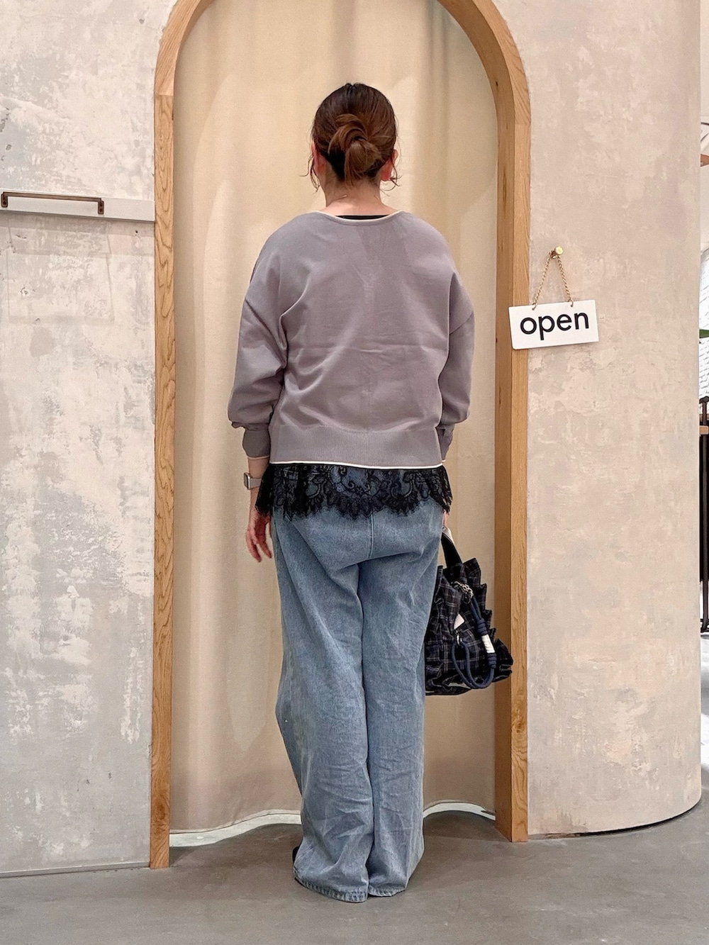 ブルー系のデニムパンツ、ブルー系のショルダーバッグ、ブラック系のパンプスを着用したレディースの秋コーディネートの3枚目の写真