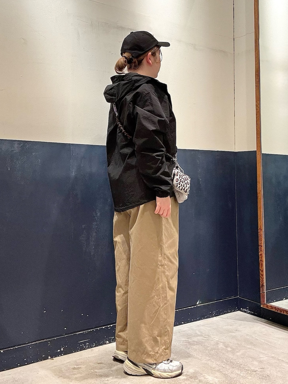 グレー系のTシャツ/カットソー、ブラック系のマウンテンパーカー、ベージュ系のデニムパンツを着用したレディースの春コーディネートの2枚目の写真