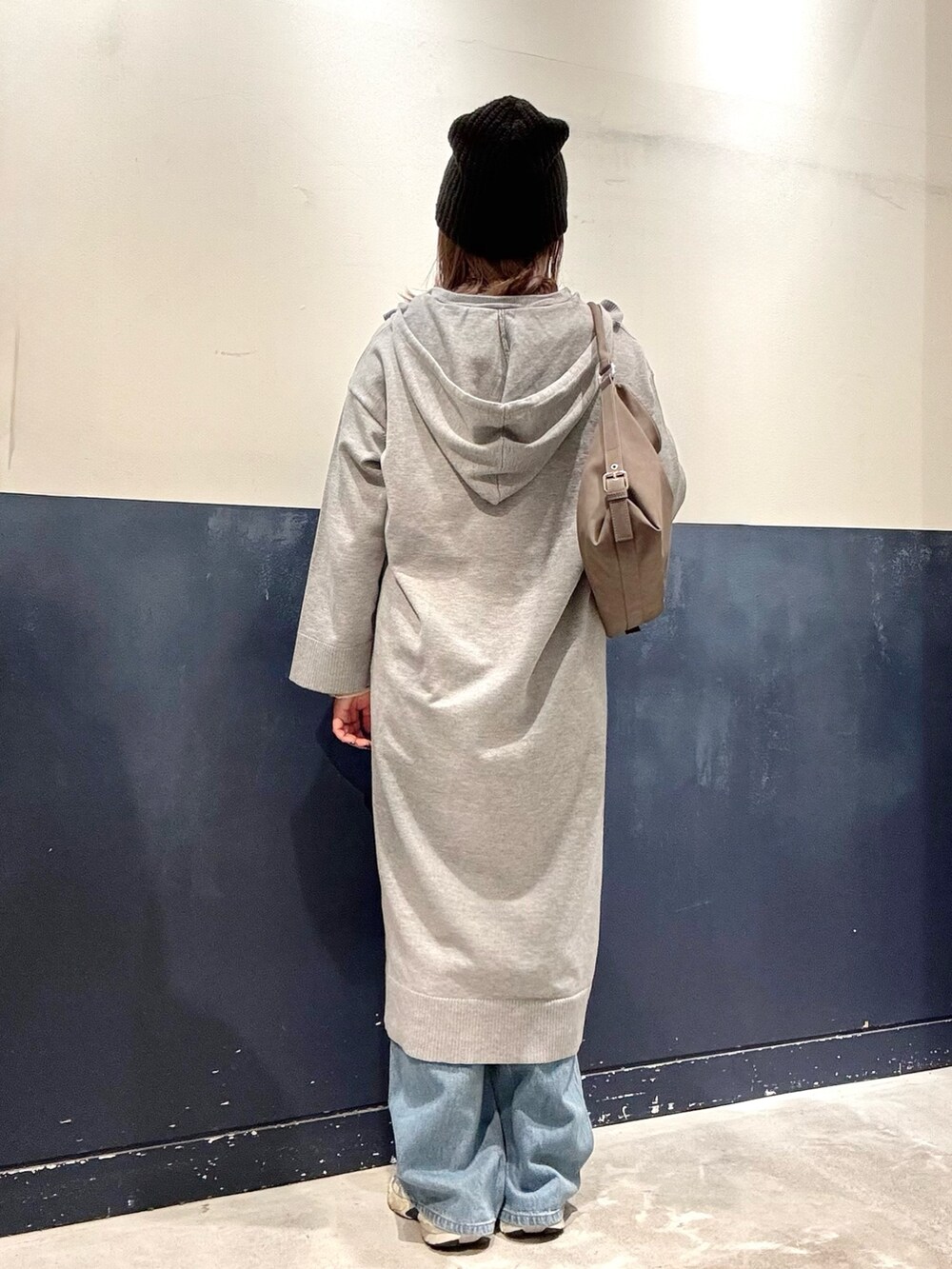 グレー系のワンピース、ホワイト系のニット/セーター、ブラウン系のショルダーバッグを着用したレディースの秋コーディネートの3枚目の写真