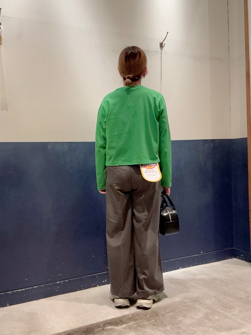 グリーン系のカーディガン/ボレロ、ホワイト系のTシャツ/カットソー、グレー系のパンツを着用したレディースの春コーディネートの3枚目の写真