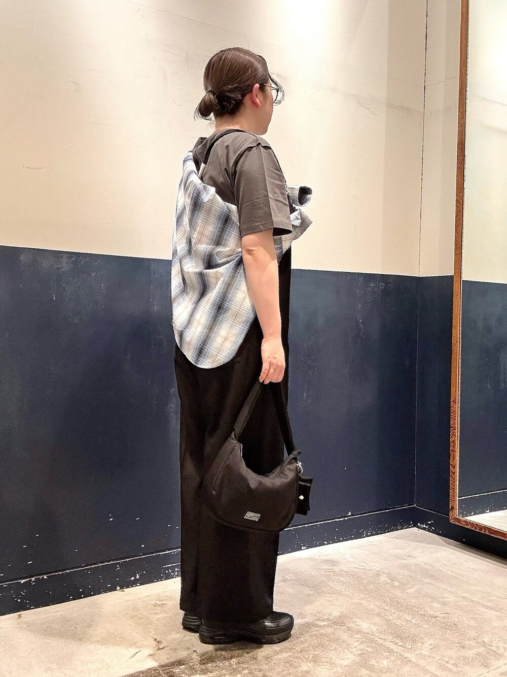 グレー系のTシャツ/カットソー、ホワイト系のシャツ/ブラウス、ブラック系のサロペット/オーバーオールを着用したレディースの春コーディネートの2枚目の写真