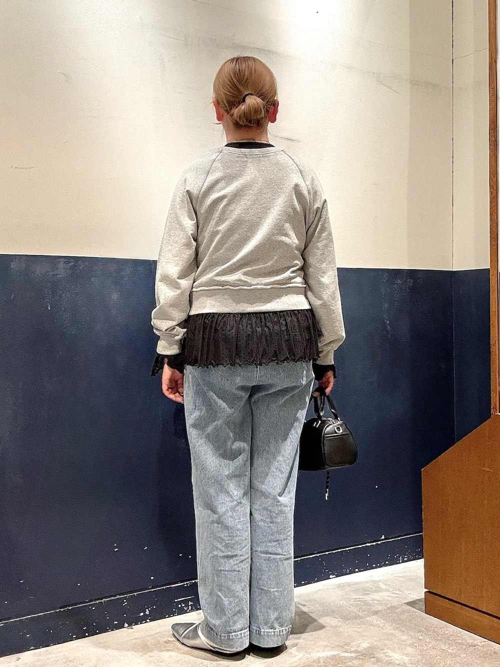 ブルー系のデニムパンツ、ブラック系のショルダーバッグ、シルバー系のパンプスを着用したレディースの冬コーディネートの3枚目の写真