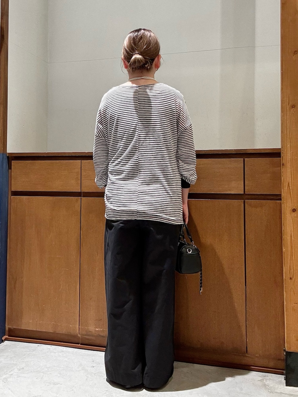 グレー系のTシャツ/カットソー、ブラック系のスニーカー、ブラック系のショルダーバッグを着用したレディースの春コーディネートの3枚目の写真