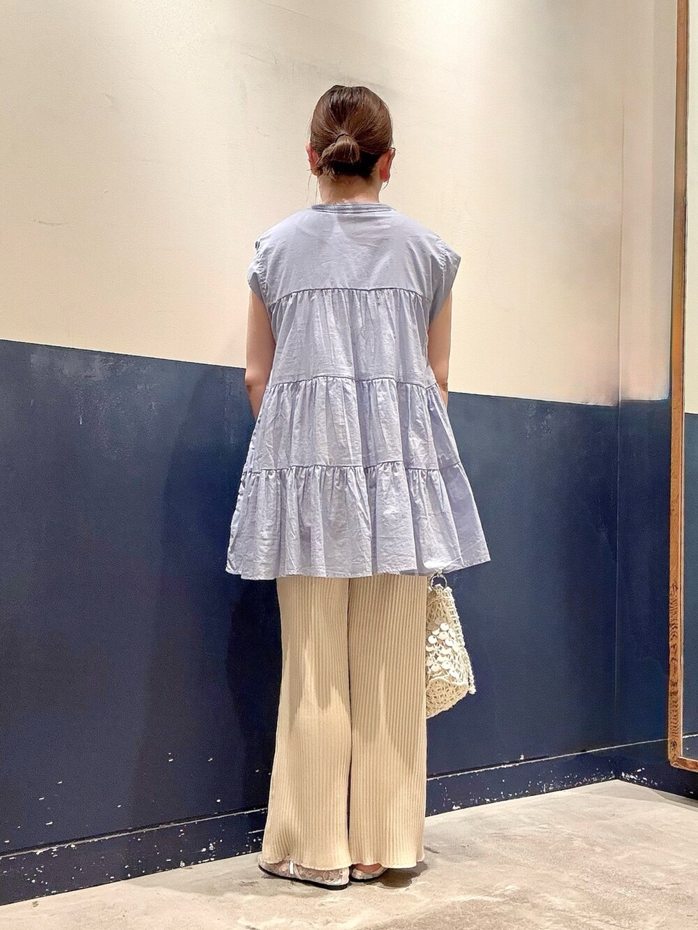 ホワイト系のパンプス、ホワイト系のショルダーバッグ、ホワイト系のスウェットパンツを着用したレディースの夏コーディネートの3枚目の写真