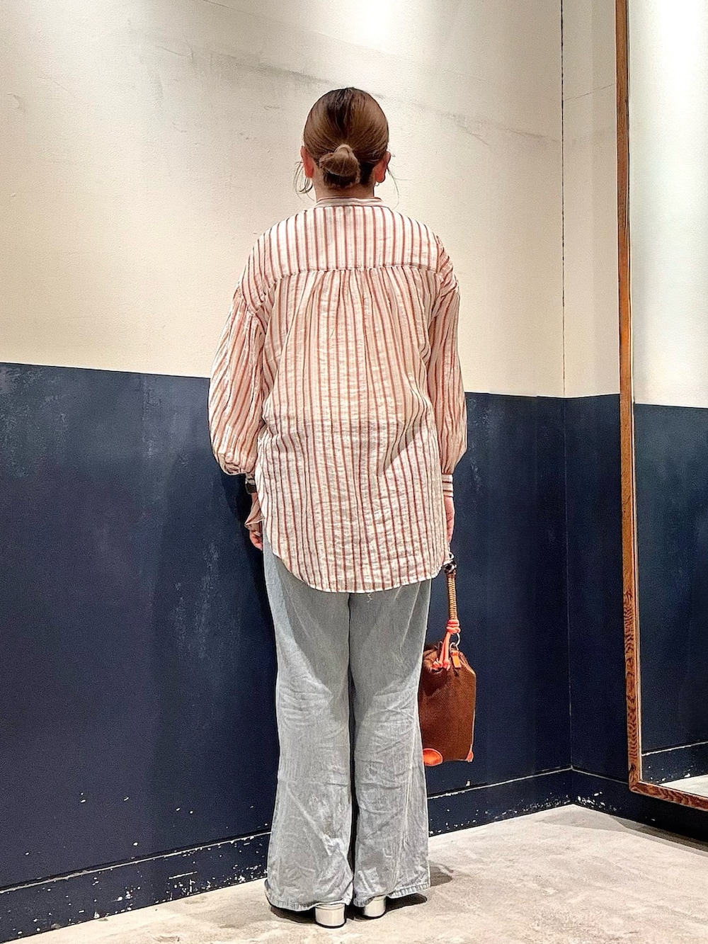 イエロー系のショルダーバッグ、ブルー系のデニムパンツ、ホワイト系のタンクトップを着用したレディースの夏コーディネートの3枚目の写真