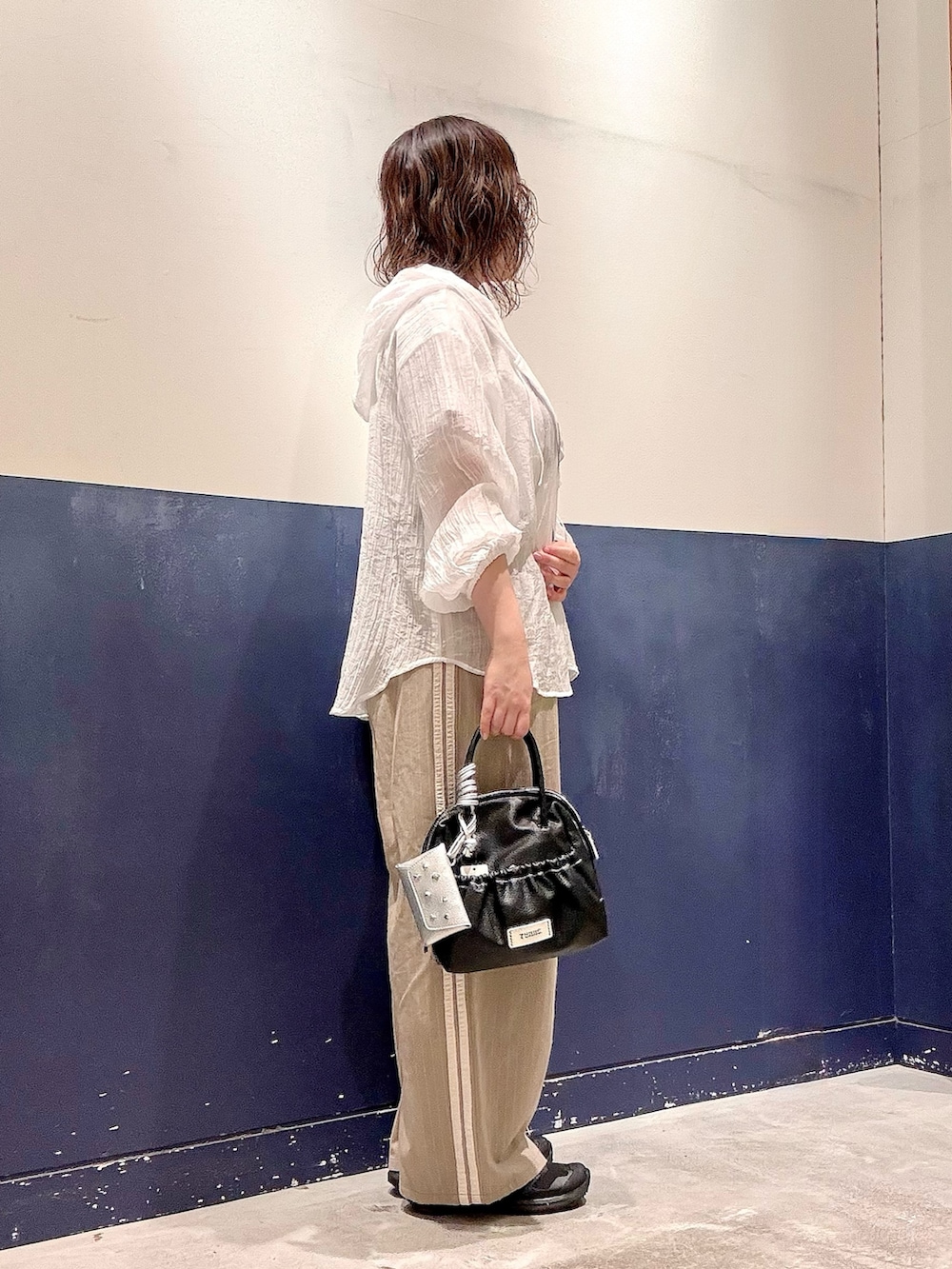 ホワイト系のシャツ/ブラウス、ホワイト系のTシャツ/カットソー、ベージュ系のスラックスを着用したレディースの夏コーディネートの2枚目の写真