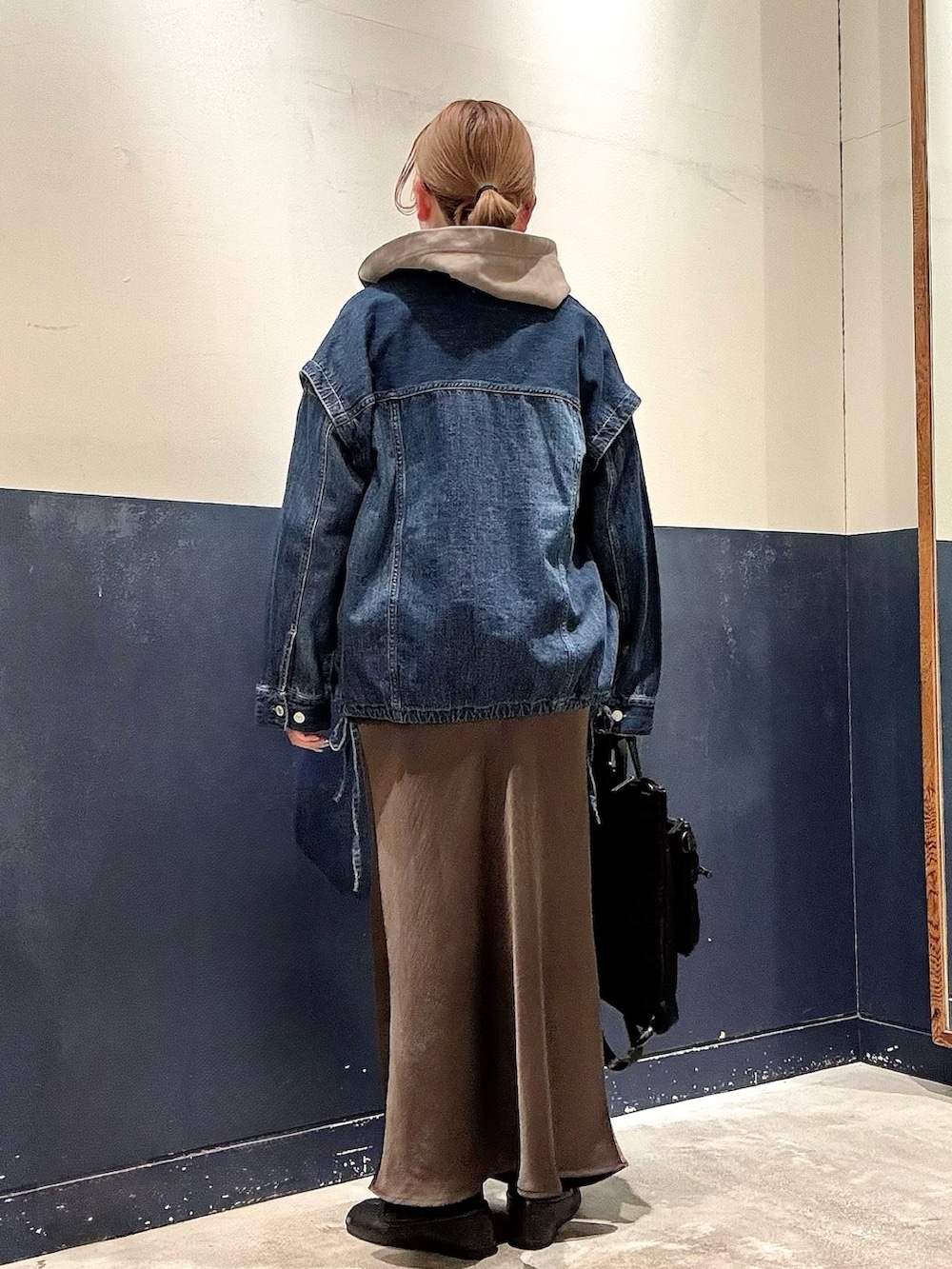 ブラック系のショルダーバッグ、グレー系のスカート、ブルー系のデニムジャケットを着用したレディースの冬コーディネートの3枚目の写真