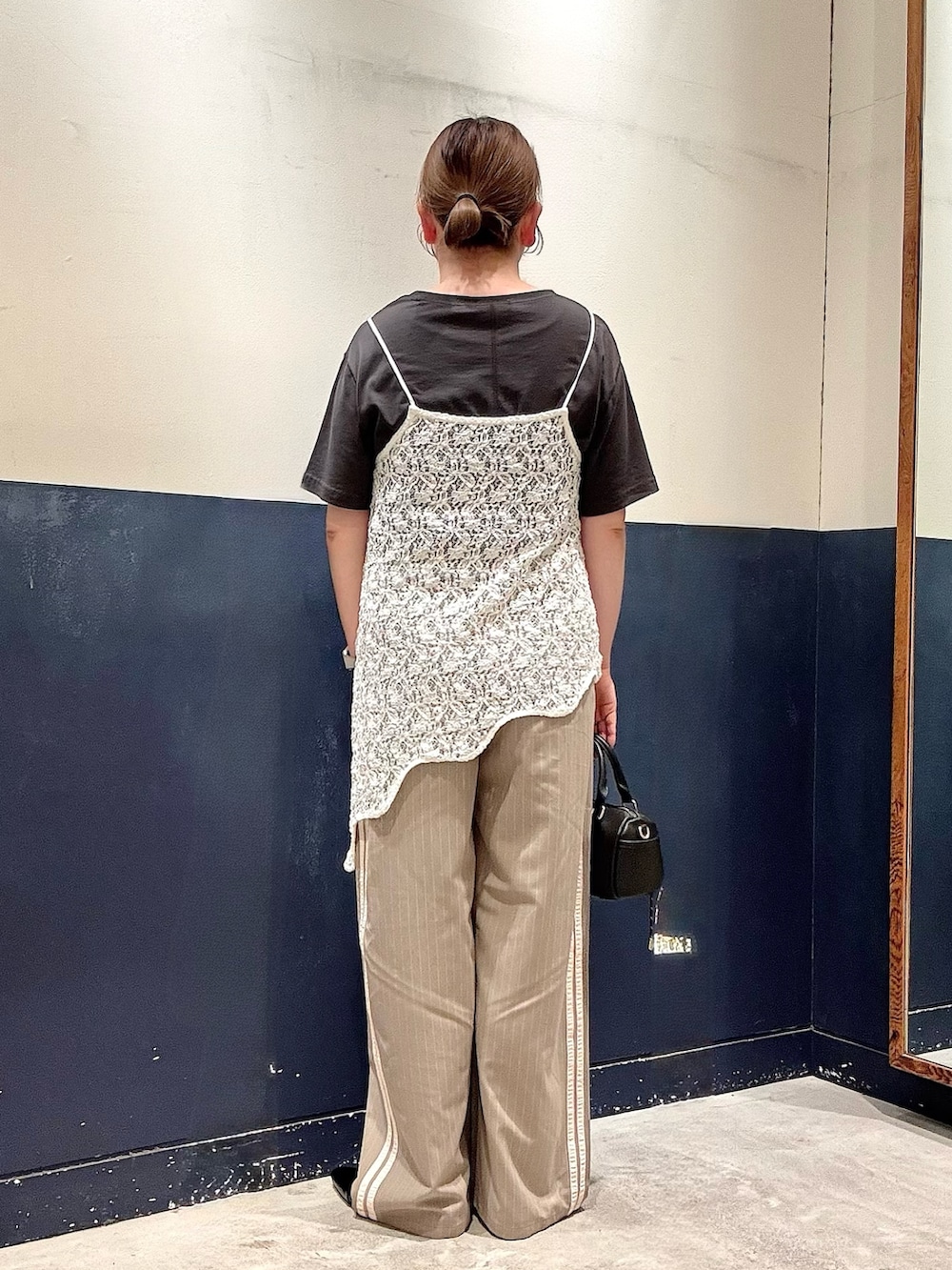 ブラック系のパンプス、ベージュ系のスラックス、ホワイト系のタンクトップを着用したレディースの春コーディネートの3枚目の写真