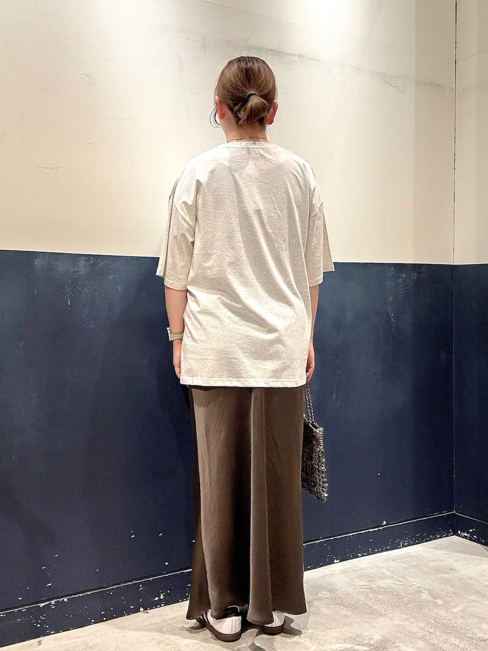 グレー系のスカート、グレー系のショルダーバッグ、ホワイト系のTシャツ/カットソーを着用したレディースの春コーディネートの3枚目の写真
