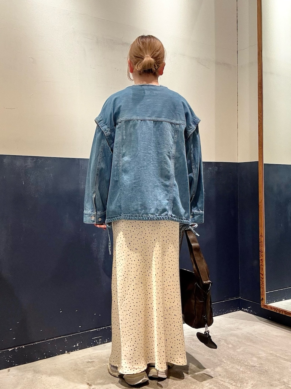 ホワイト系のスカート、ブルー系のデニムジャケット、ベージュ系のTシャツ/カットソーを着用したレディースの春コーディネートの3枚目の写真