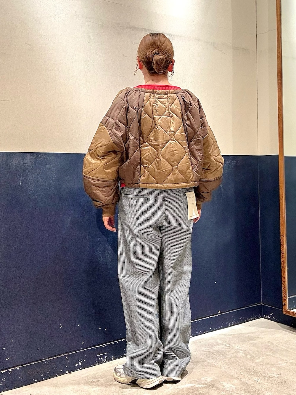 イエロー系のブルゾン、レッド系のカーディガン/ボレロ、ブルー系のデニムパンツを着用したレディースの冬コーディネートの3枚目の写真