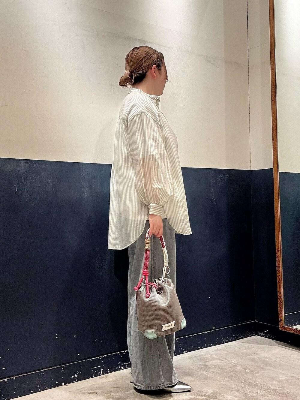グレー系のショルダーバッグ、ブルー系のデニムパンツ、グリーン系のシャツ/ブラウスを着用したレディースの夏コーディネートの2枚目の写真