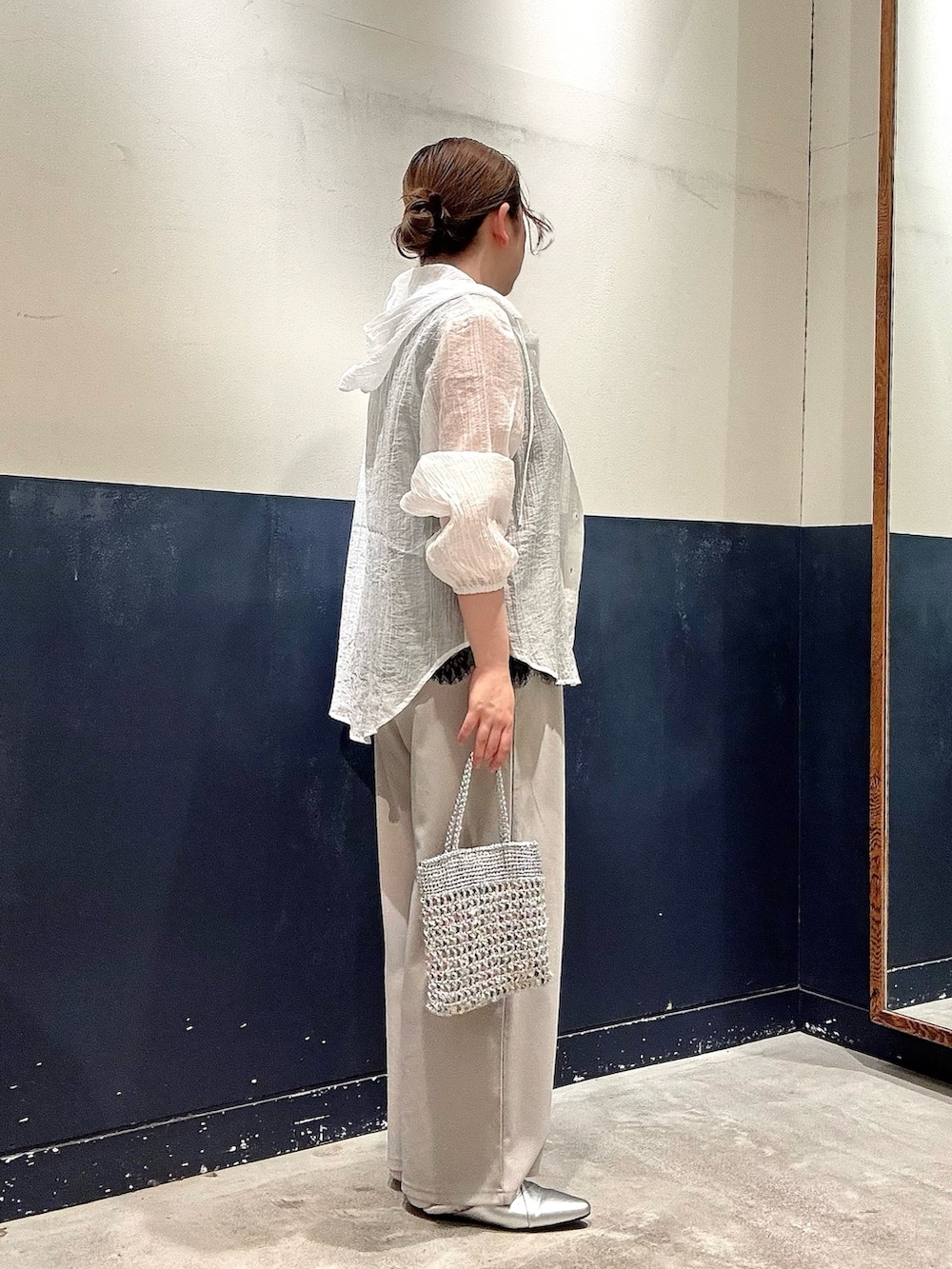 シルバー系のパンプス、シルバー系のショルダーバッグ、グレー系のスラックスを着用したレディースの春コーディネートの2枚目の写真