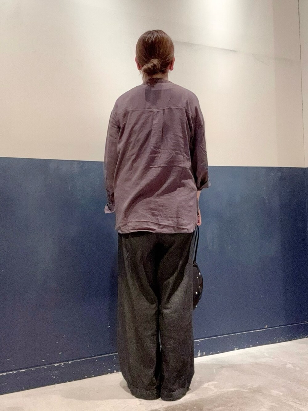 ブラック系のデニムパンツ、ブラック系のハンドバッグ、グレー系のシャツ/ブラウスを着用したレディースの夏コーディネートの3枚目の写真