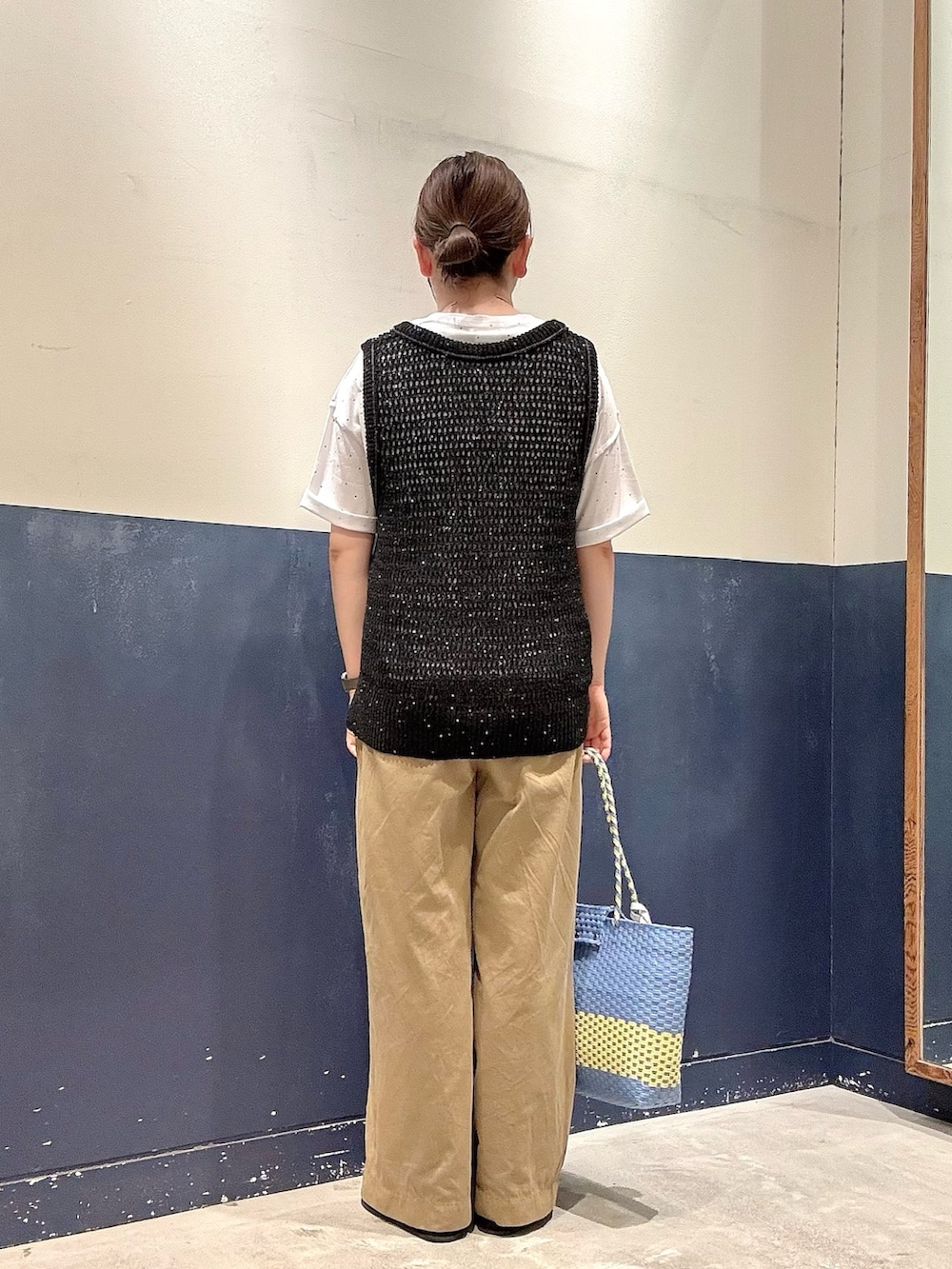 ブルー系のトートバッグ、ベージュ系のデニムパンツ、イエロー系のサンダルを着用したレディースの夏コーディネートの3枚目の写真