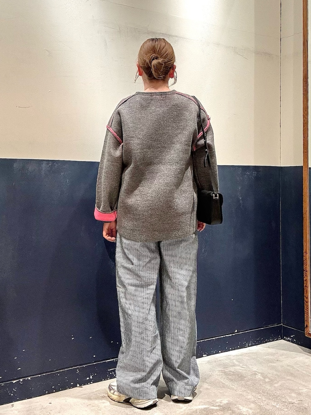 グレー系のカーディガン/ボレロ、ブルー系のデニムパンツ、ブラック系のショルダーバッグを着用したレディースの冬コーディネートの3枚目の写真