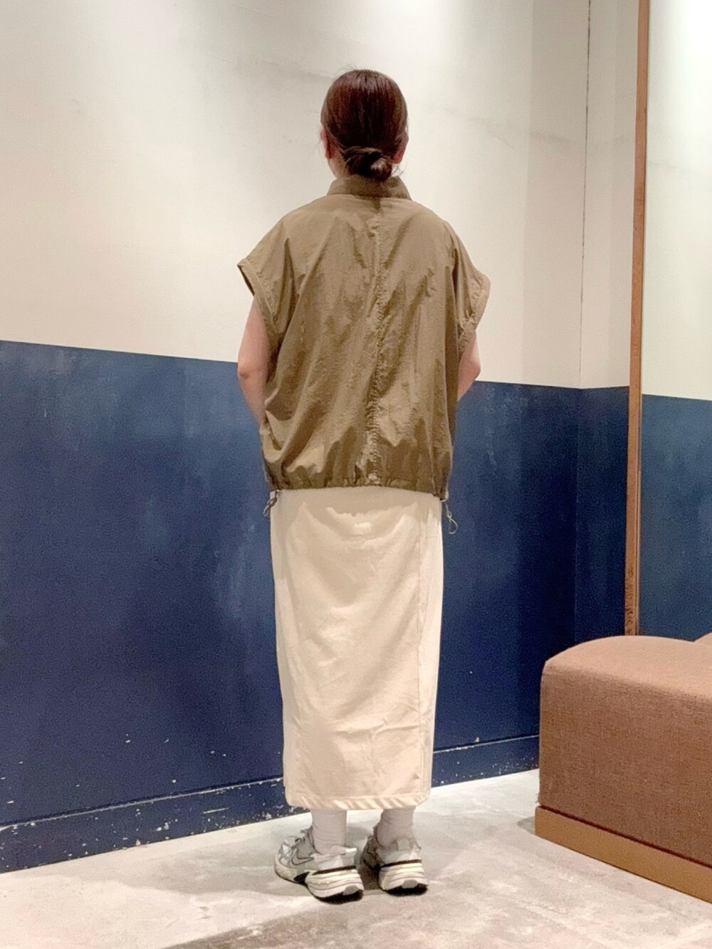 ホワイト系のトートバッグ、ベージュ系のナイロンジャケット、グレー系のワンピースを着用したレディースの夏コーディネートの3枚目の写真