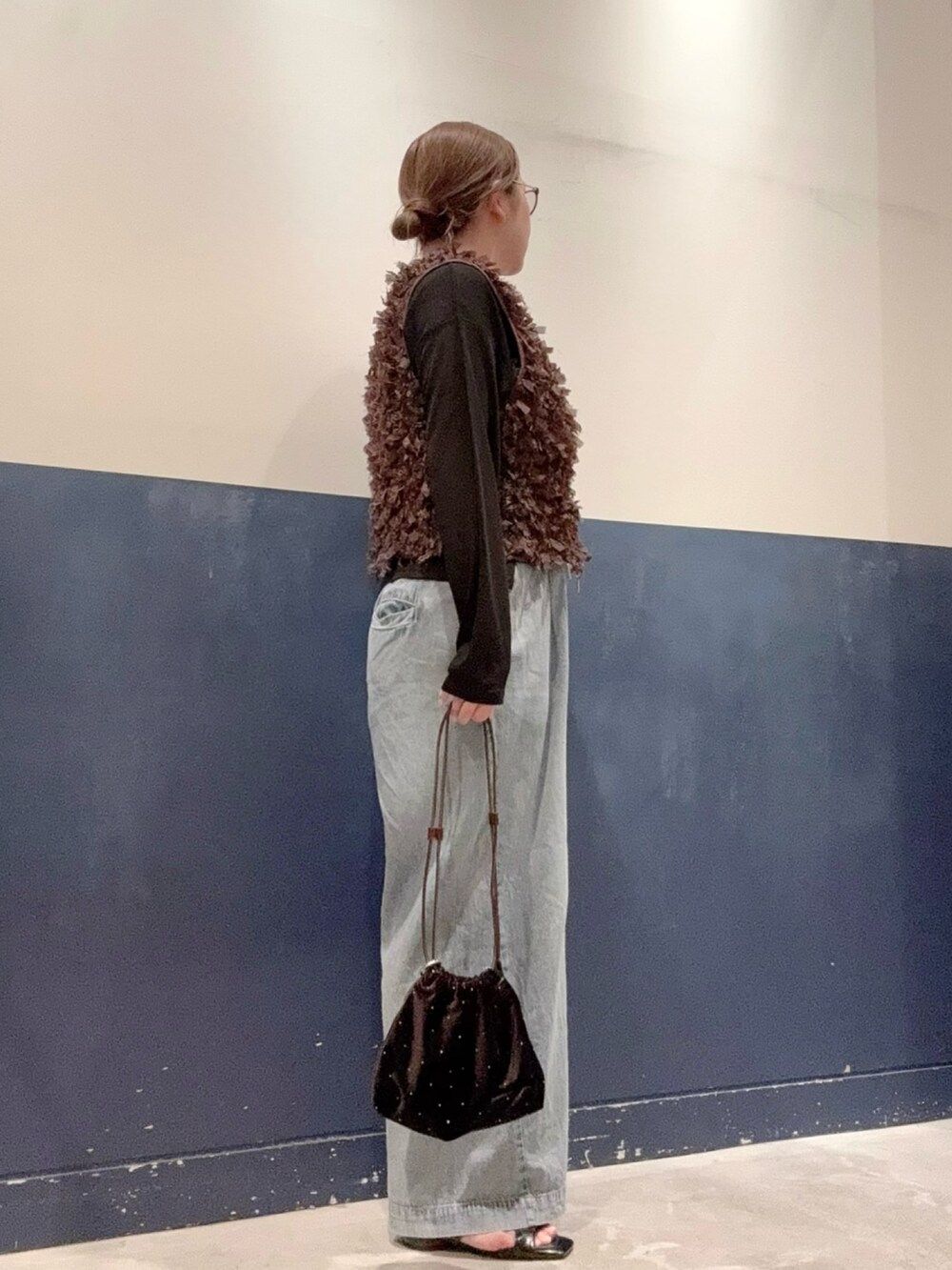 ブラウン系のベスト、ブラック系のTシャツ/カットソー、ブルー系のデニムパンツを着用したレディースの夏コーディネートの2枚目の写真
