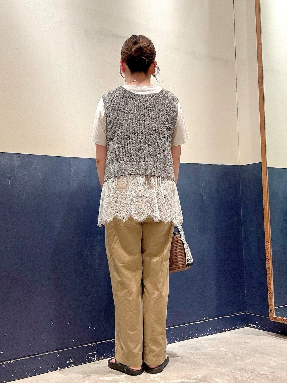 ブラウン系のトートバッグ、ベージュ系のデニムパンツ、ホワイト系のTシャツ/カットソーを着用したレディースの夏コーディネートの3枚目の写真