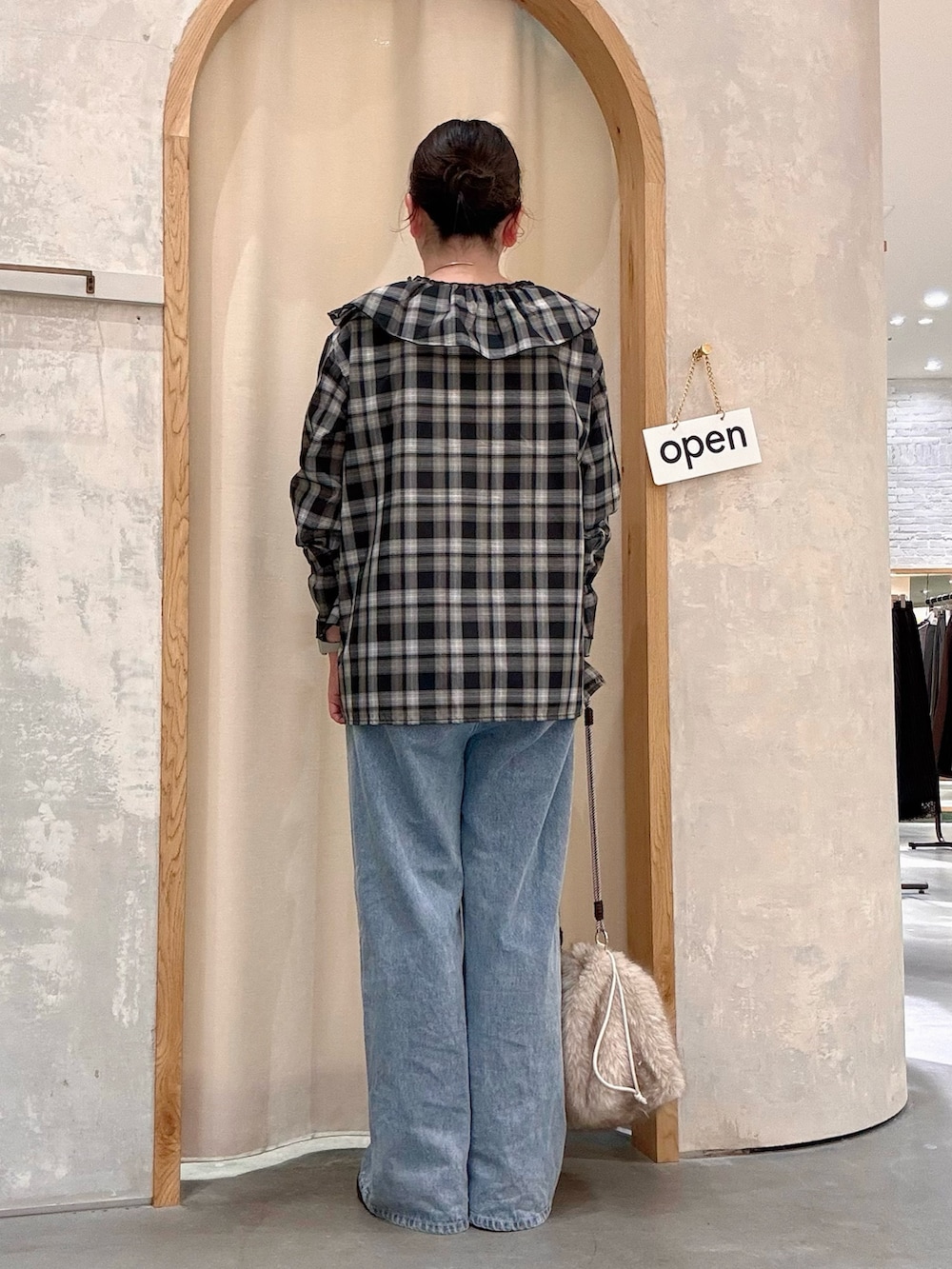 ベージュ系のトートバッグ、ブラック系のシャツ/ブラウス、ブルー系のデニムパンツを着用したレディースの秋コーディネートの3枚目の写真