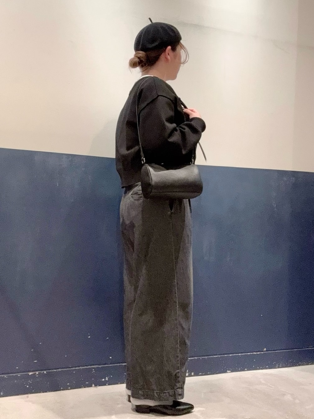 ブラック系のパンプス、ブラック系のデニムパンツ、ブラック系のショルダーバッグを着用したレディースの秋コーディネートの2枚目の写真