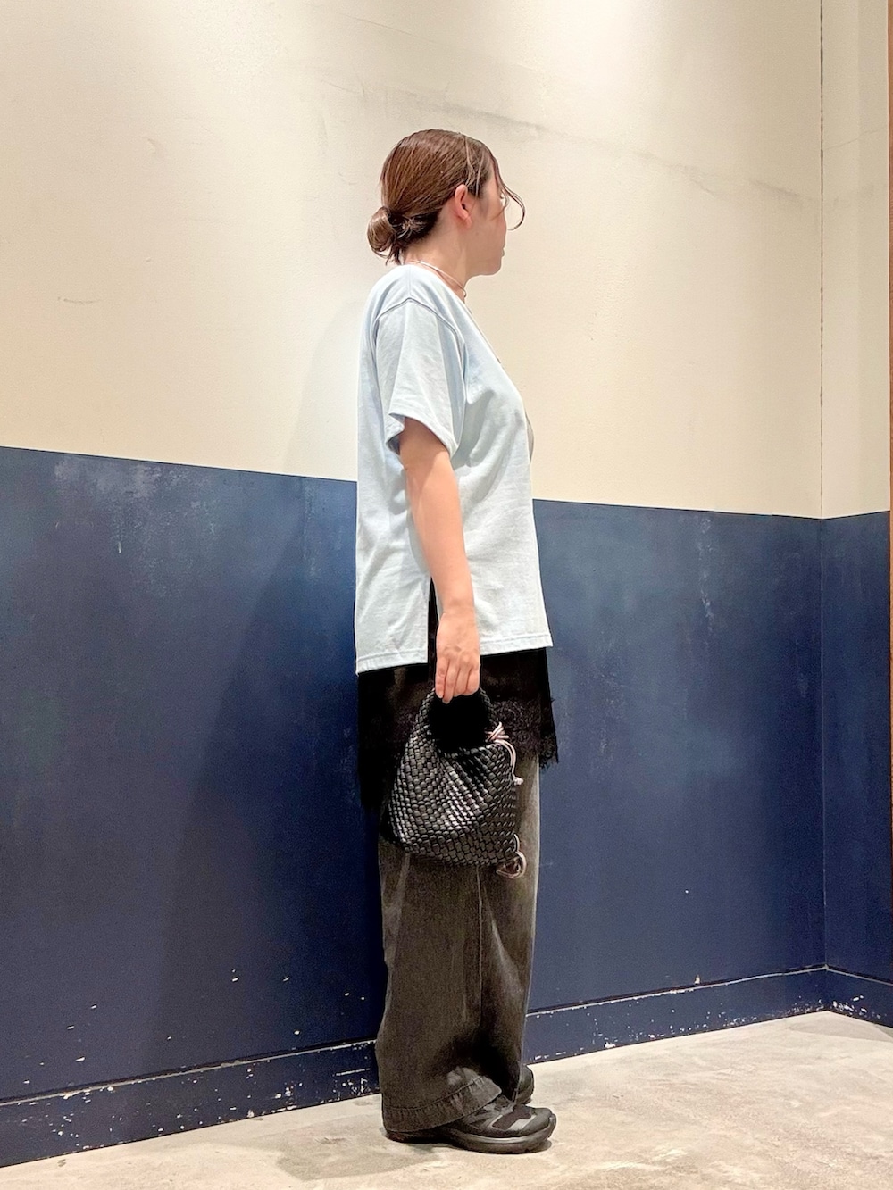 ブラック系のショルダーバッグ、ブラック系のデニムパンツ、ブルー系のTシャツ/カットソーを着用したレディースの夏コーディネートの2枚目の写真