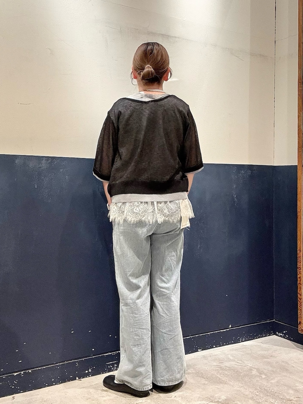 ブルー系のデニムパンツ、ブラック系のカーディガン/ボレロ、グレー系のタンクトップを着用したレディースの春コーディネートの3枚目の写真