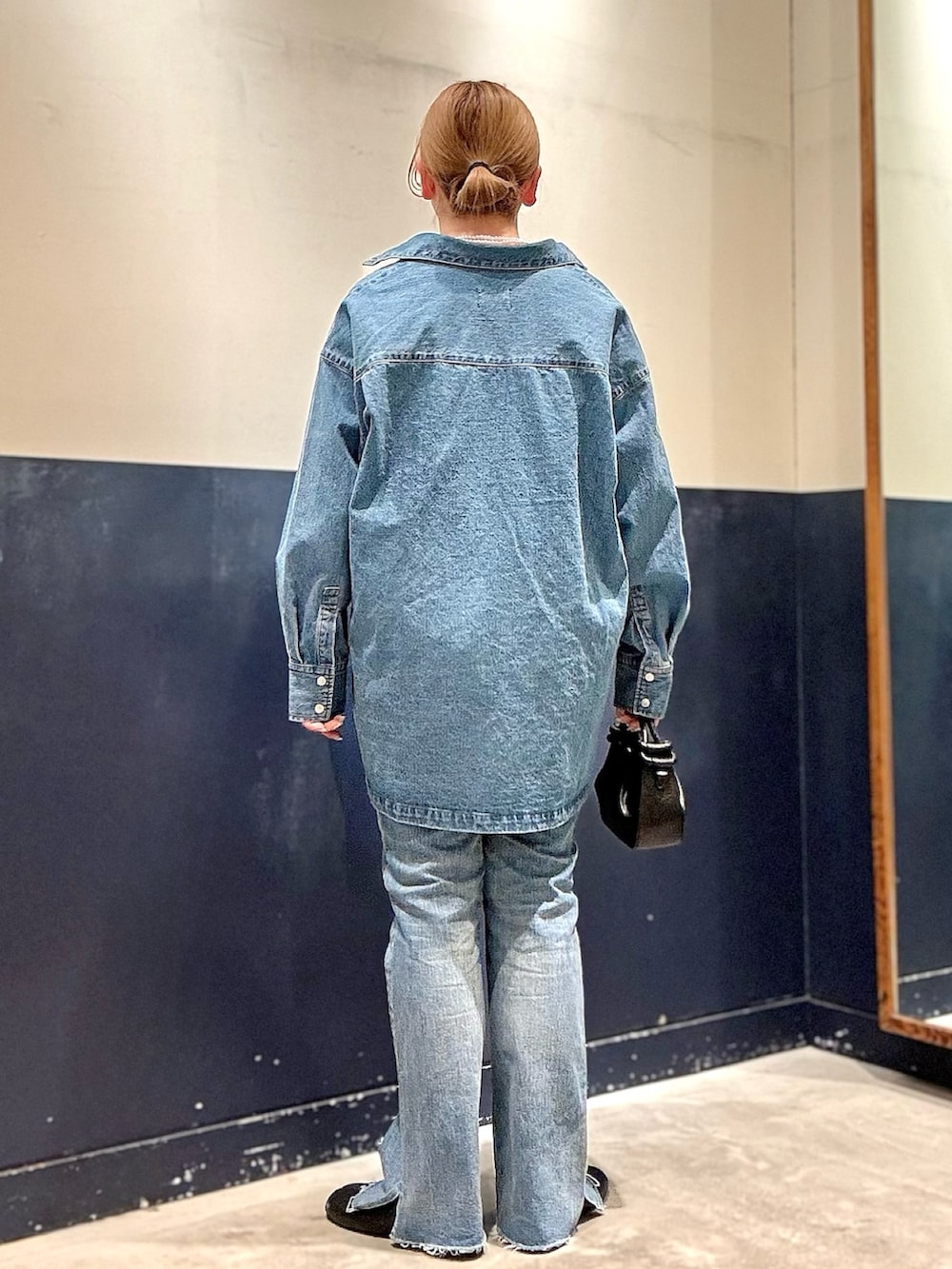 ブルー系のデニムパンツ、ブラック系のショルダーバッグ、ブルー系のデニムジャケットを着用したレディースの冬コーディネートの3枚目の写真