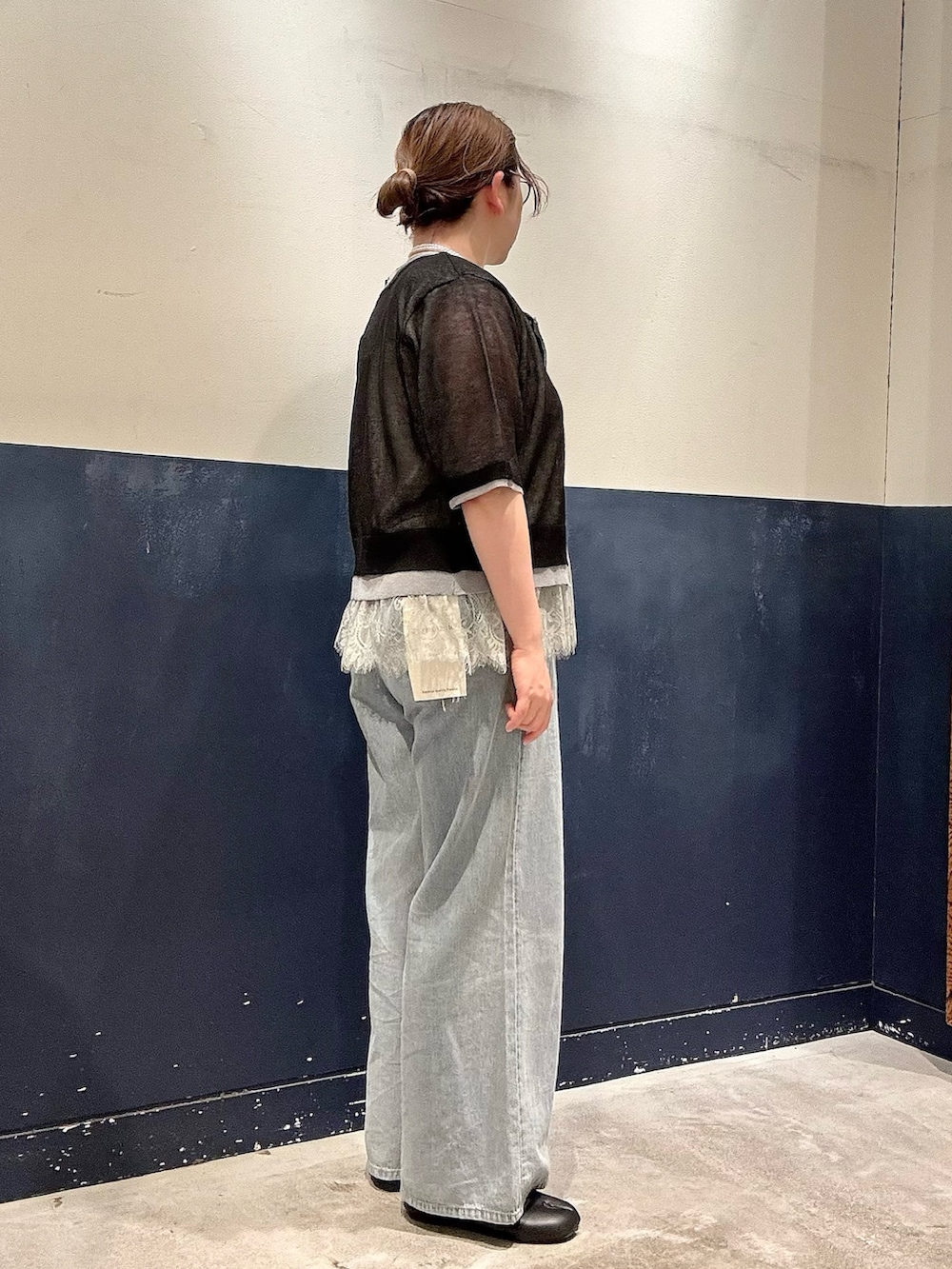 ブルー系のデニムパンツ、ブラック系のカーディガン/ボレロ、グレー系のタンクトップを着用したレディースの春コーディネートの2枚目の写真