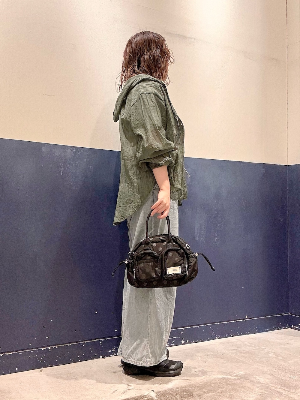 ブルー系のデニムパンツ、ブラック系のショルダーバッグ、グリーン系のシャツ/ブラウスを着用したレディースの夏コーディネートの2枚目の写真