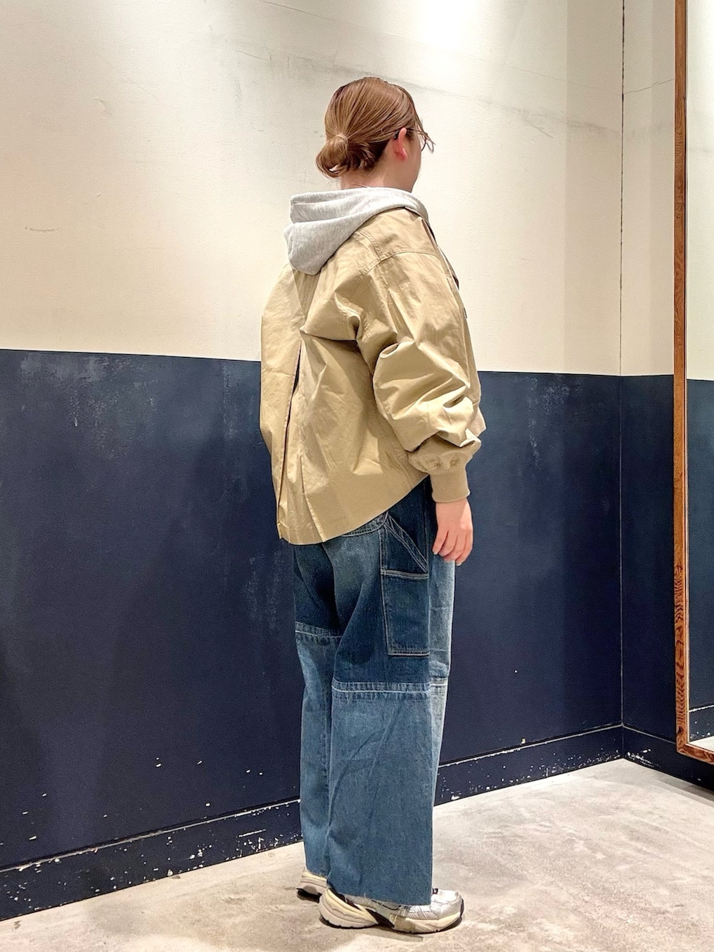 ブルー系のデニムパンツ、ベージュ系のトレンチコート、グレー系のTシャツ/カットソーを着用したレディースの春コーディネートの2枚目の写真