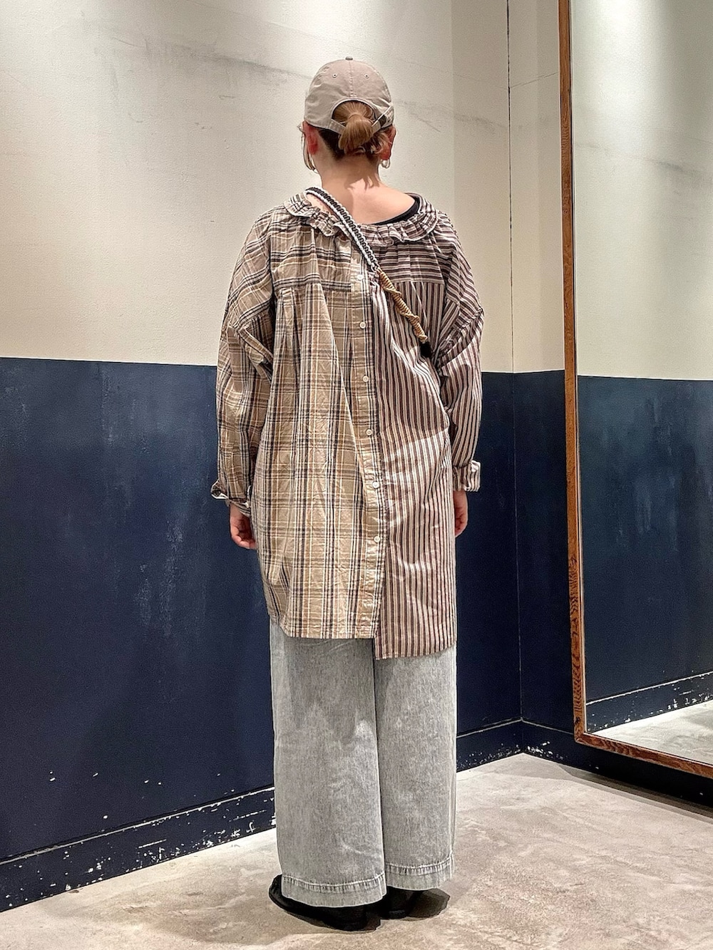 ブルー系のデニムパンツ、ブラック系のローファー、ブラウン系のスカートを着用したレディースの春コーディネートの3枚目の写真