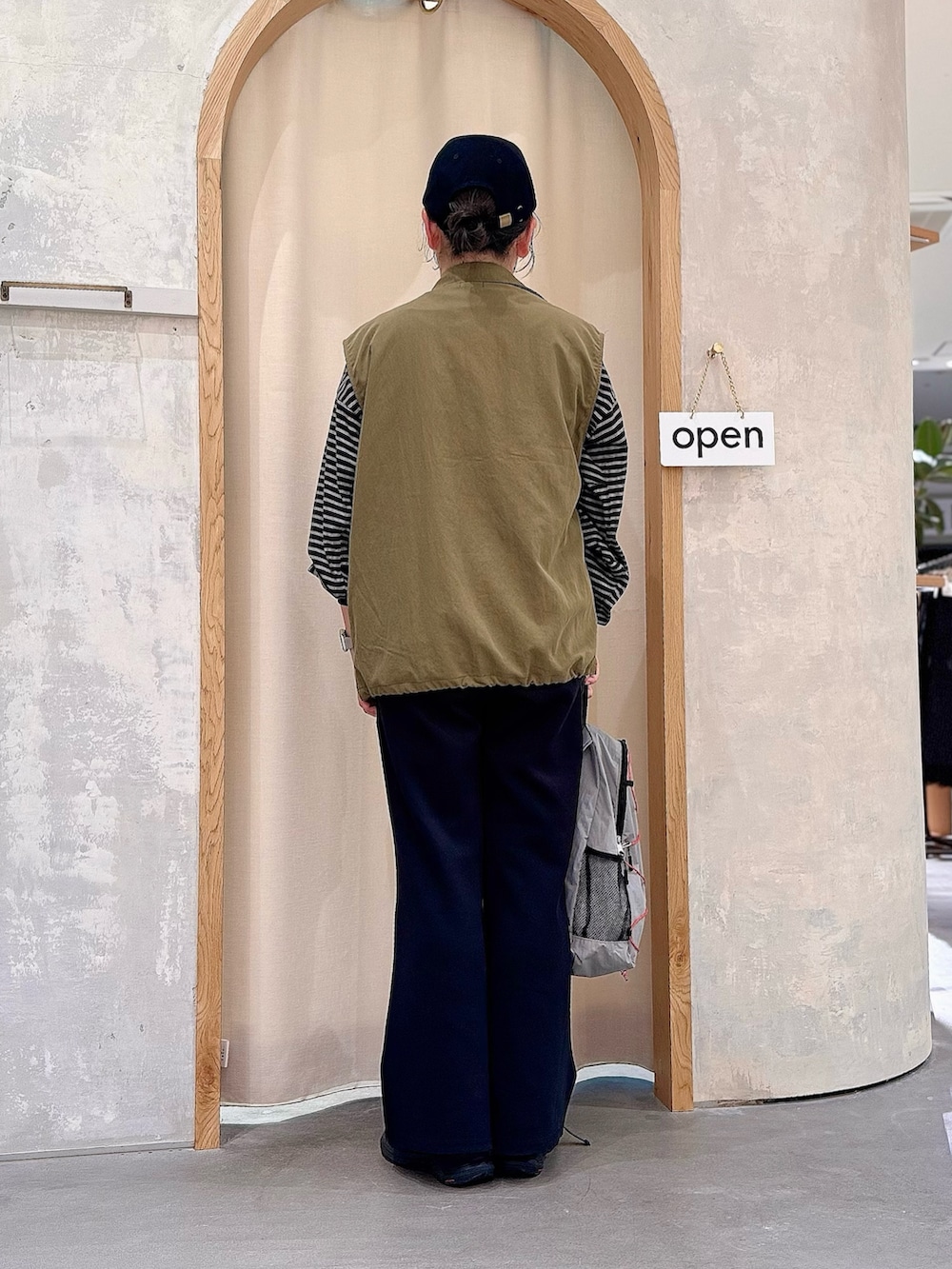 グレー系のバックパック/リュック、ブラック系のその他パンツ、グリーン系のベストを着用したレディースの秋コーディネートの3枚目の写真