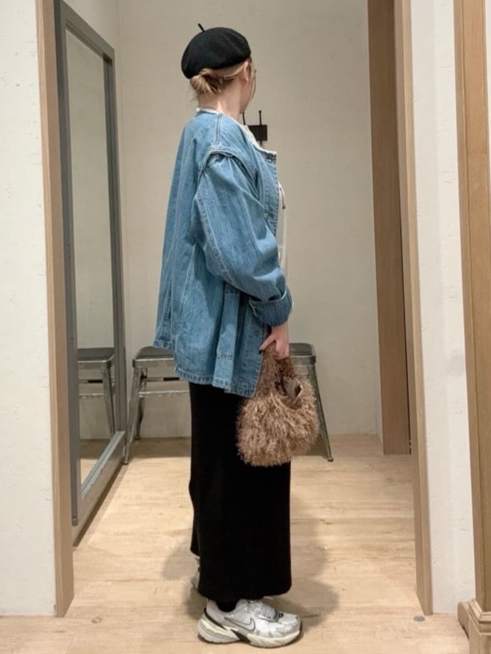 ブルー系のデニムジャケット、ブラック系のスカート、グレー系のスウェットを着用したレディースの秋コーディネートの2枚目の写真