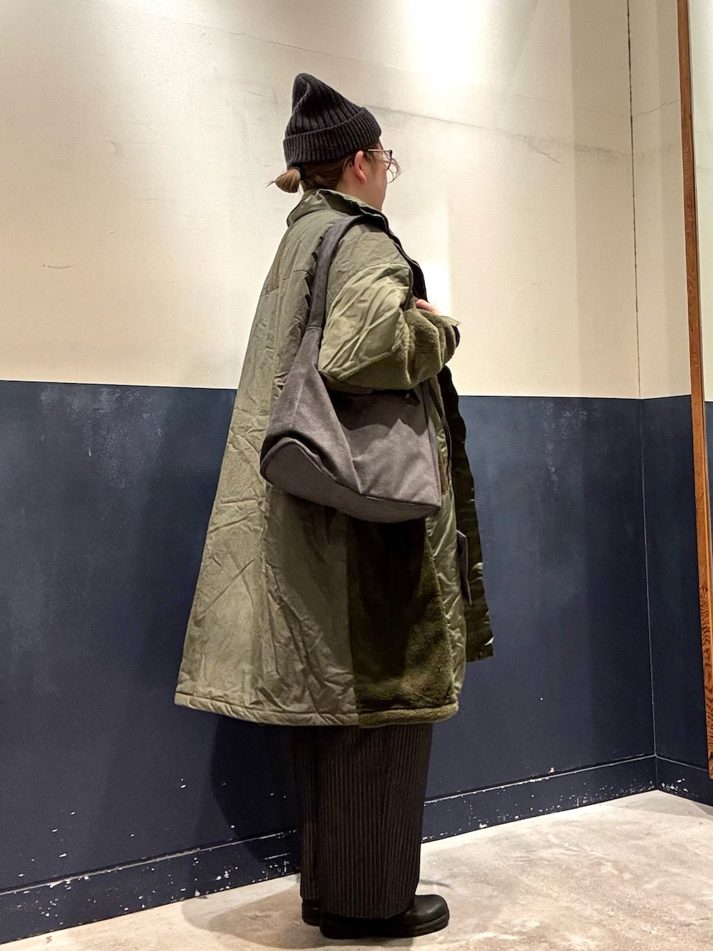 グレー系のニット/セーター、グリーン系のモッズコート、グレー系のトートバッグを着用したレディースの冬コーディネートの2枚目の写真